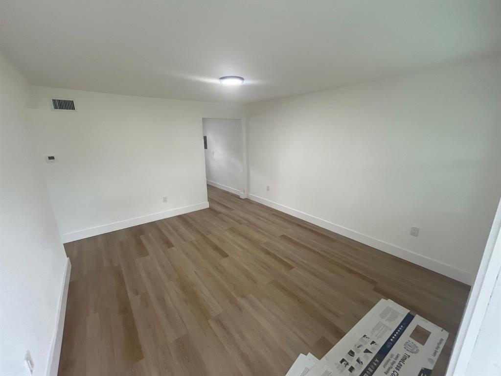 1457 West 31st Street, Unit 2 Riviera Beach, FL 33404 - Photo 3 of 16 an empty room with wooden floor