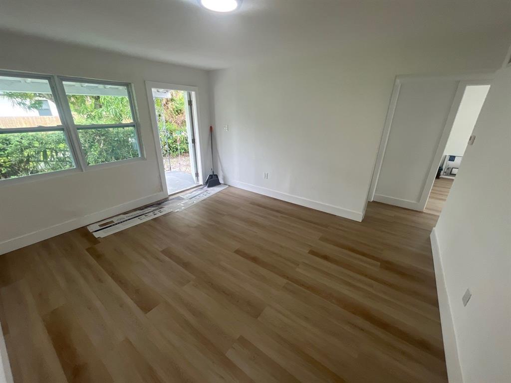 1457 West 31st Street, Unit 2 Riviera Beach, FL 33404 - Photo 5 of 16 a view of an empty room with wooden floor and a window