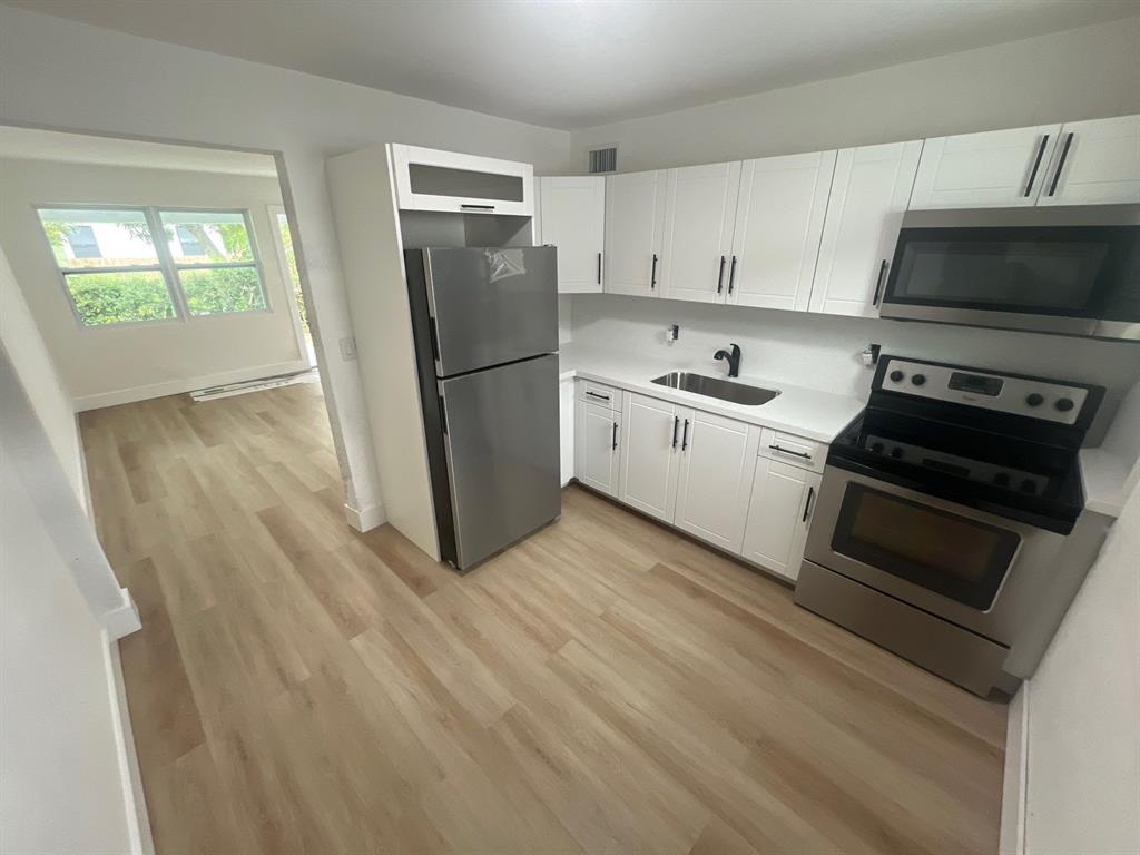 1457 West 31st Street, Unit 2 Riviera Beach, FL 33404 - Photo 6 of 16 a kitchen with a refrigerator stove and sink