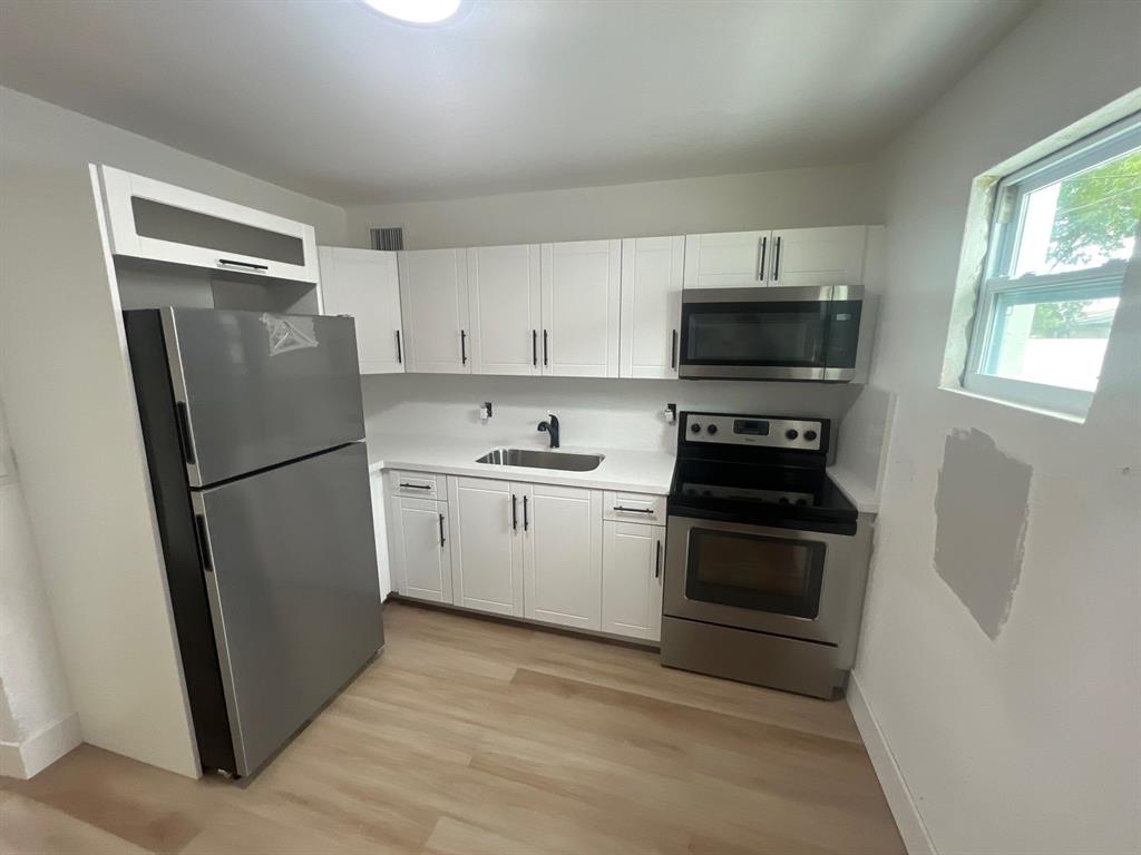 1457 West 31st Street, Unit 2 Riviera Beach, FL 33404 - Photo 7 of 16 a kitchen with a refrigerator stove and sink