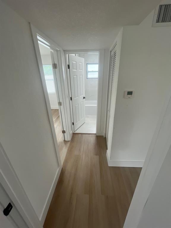 1457 West 31st Street, Unit 2 Riviera Beach, FL 33404 - Photo 9 of 16 a view of a hallway with wooden floor and staircase