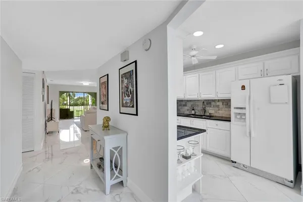 a kitchen with white cabinets and white appliances