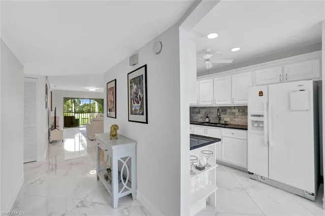 a kitchen with white cabinets and white appliances