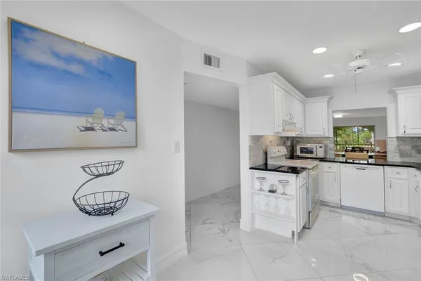 a kitchen with white cabinets and appliances
