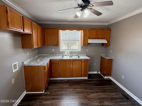a kitchen with granite countertop wood cabinets and white appliances