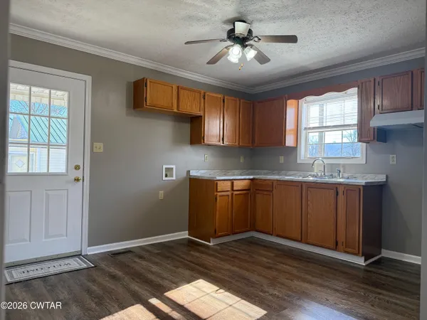 a kitchen with stainless steel appliances granite countertop wooden cabinets a window and a sink
