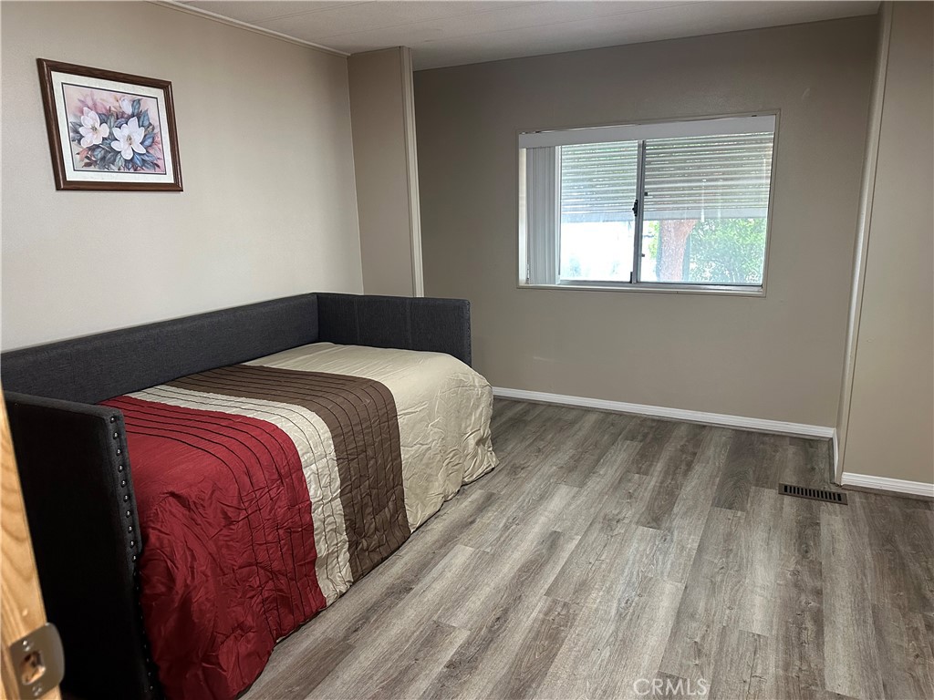 27701 Murrieta Road, Unit 268 Menifee, CA 92586 - Photo 16 of 24 a bedroom with a bed and wooden floor