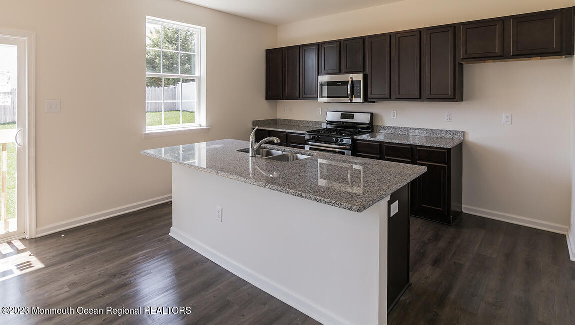 35 Phoebe Drive Barnegat, NJ 08005 - Photo 8 of 21 a kitchen with granite countertop a stove a sink and a microwave