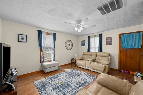 a living room with furniture ceiling fan and a rug