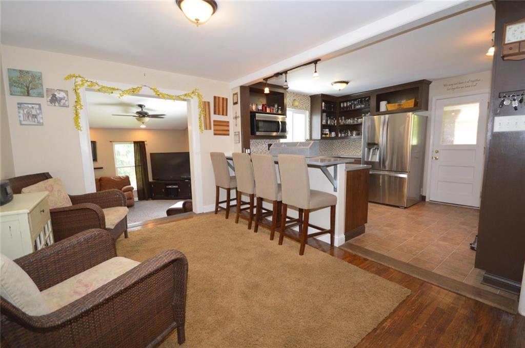 Updated kitchen with Stainless steel appliances, concrete countertops, open shelving and a cozy seating area.  Convenient door to covered side patio area makes entertaining a breeze!