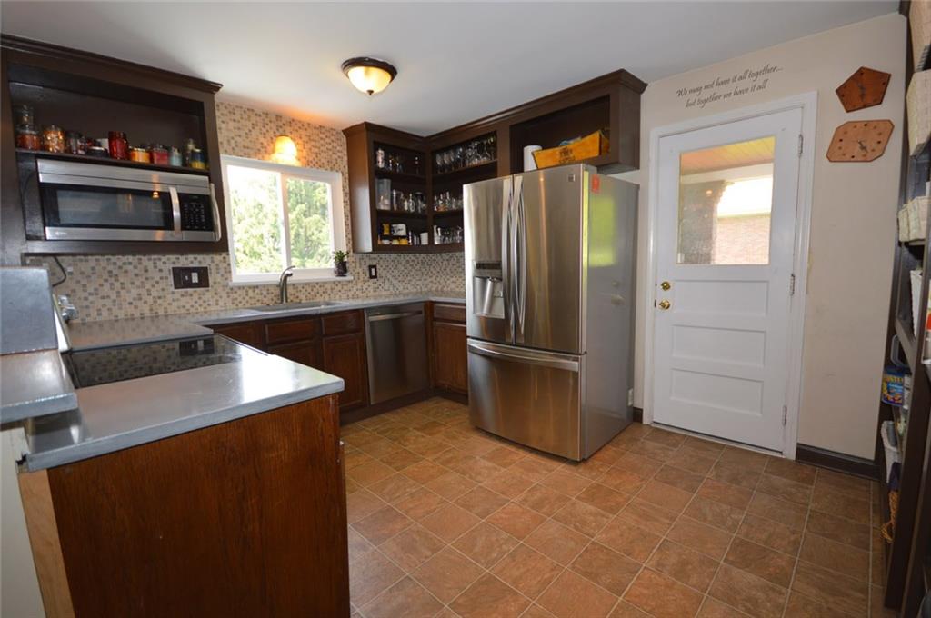 No lack of storage - there is a full wall of open shelf pantry area.  Great tile backsplash and neutral flooring and color scheme.