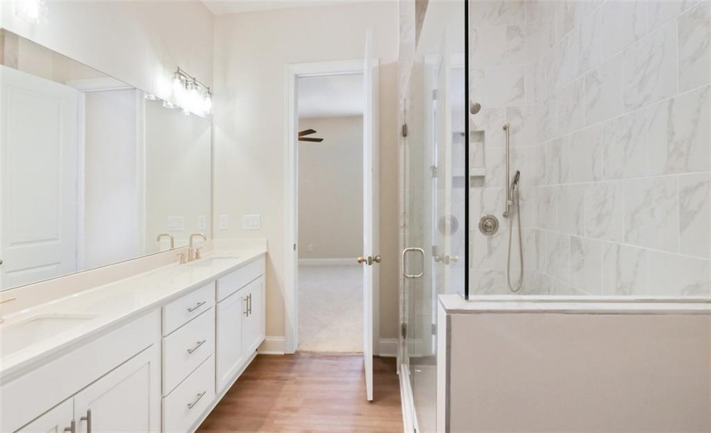 726 Stickley Oak Way Woodstock, GA 30189 - Photo 22 of 40 a bathroom with a double vanity sink a large mirror and shower