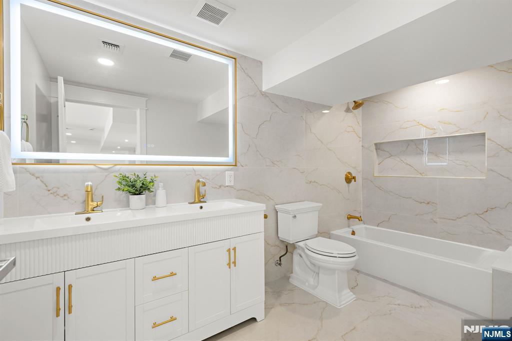 14 Beechwood Road Ho-Ho-Kus, NJ 07423 - Photo 27 of 31 a bathroom with a sink a toilet and a large mirror