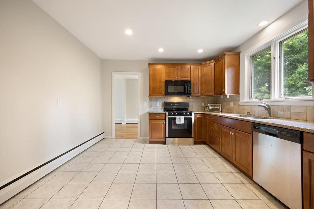 7 Riverview Avenue Maynard, MA 01754 - Photo 11 of 35 a large kitchen with a stove a sink dishwasher and a microwave oven with cabinets