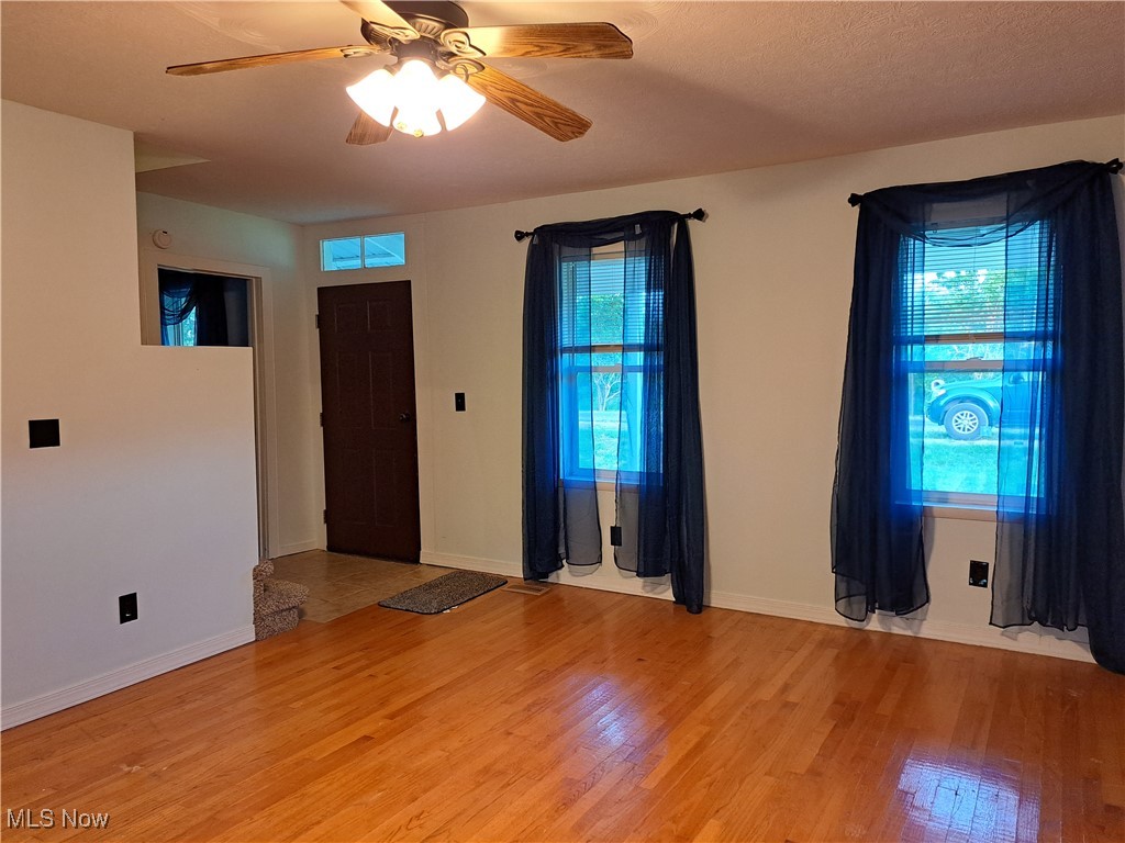 49197 John Tomcho Road Cumberland, OH 43732 - Photo 9 of 50 Empty room with ceiling fan and light wood-type flooring