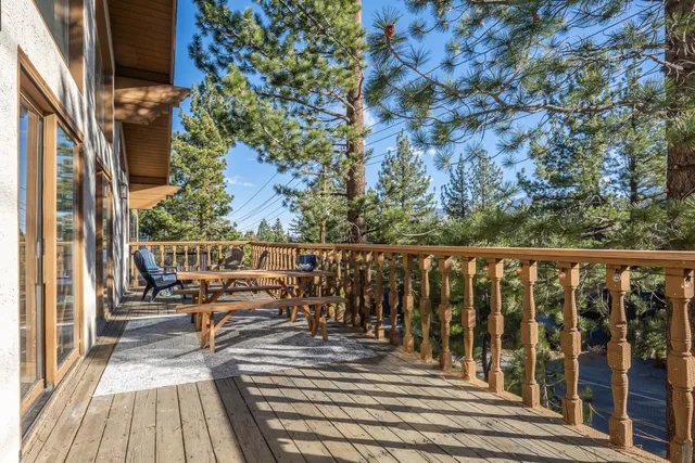 a balcony with wooden floor table and chairs