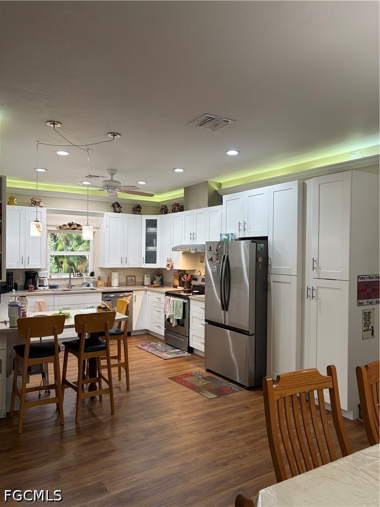 92 Evergreen Road North Fort Myers, FL 33903 - Photo 12 of 30 a kitchen with stainless steel appliances granite countertop a refrigerator a stove a dining table and chairs with wooden floor