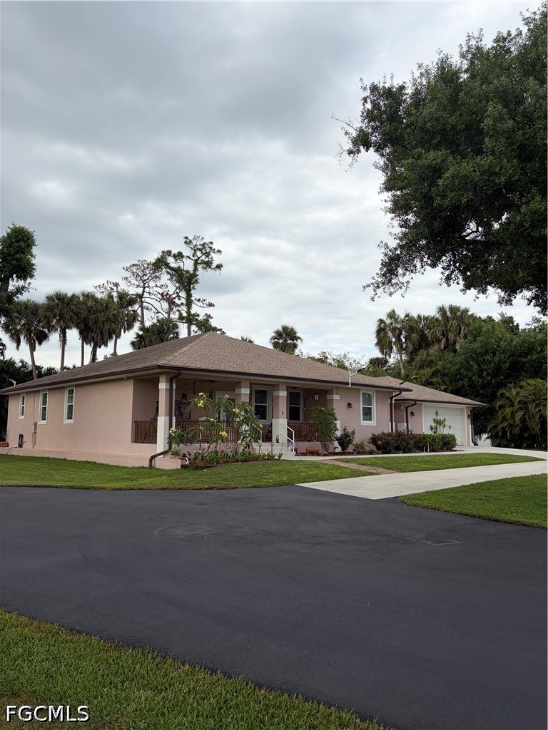 92 Evergreen Road North Fort Myers, FL 33903 - Photo 2 of 30 a front view of a house with a garden and trees