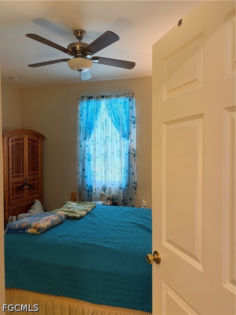 92 Evergreen Road North Fort Myers, FL 33903 - Photo 27 of 30 a bedroom with a bed and a ceiling fan