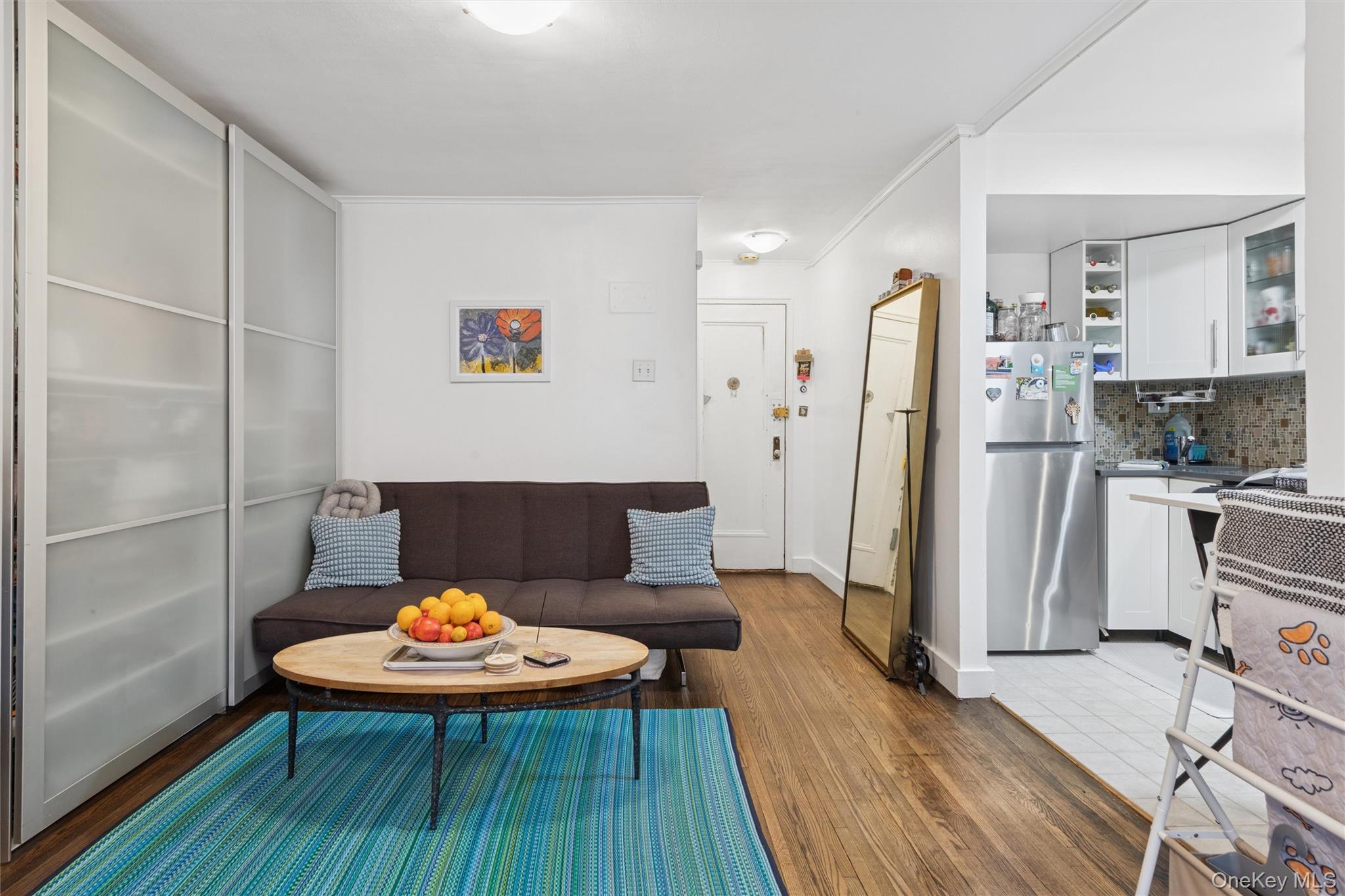 75-02 Austin Street, Unit 2C Queens, NY 11375 - Photo 3 of 6 a living room with stainless steel appliances furniture a refrigerator and wooden floor