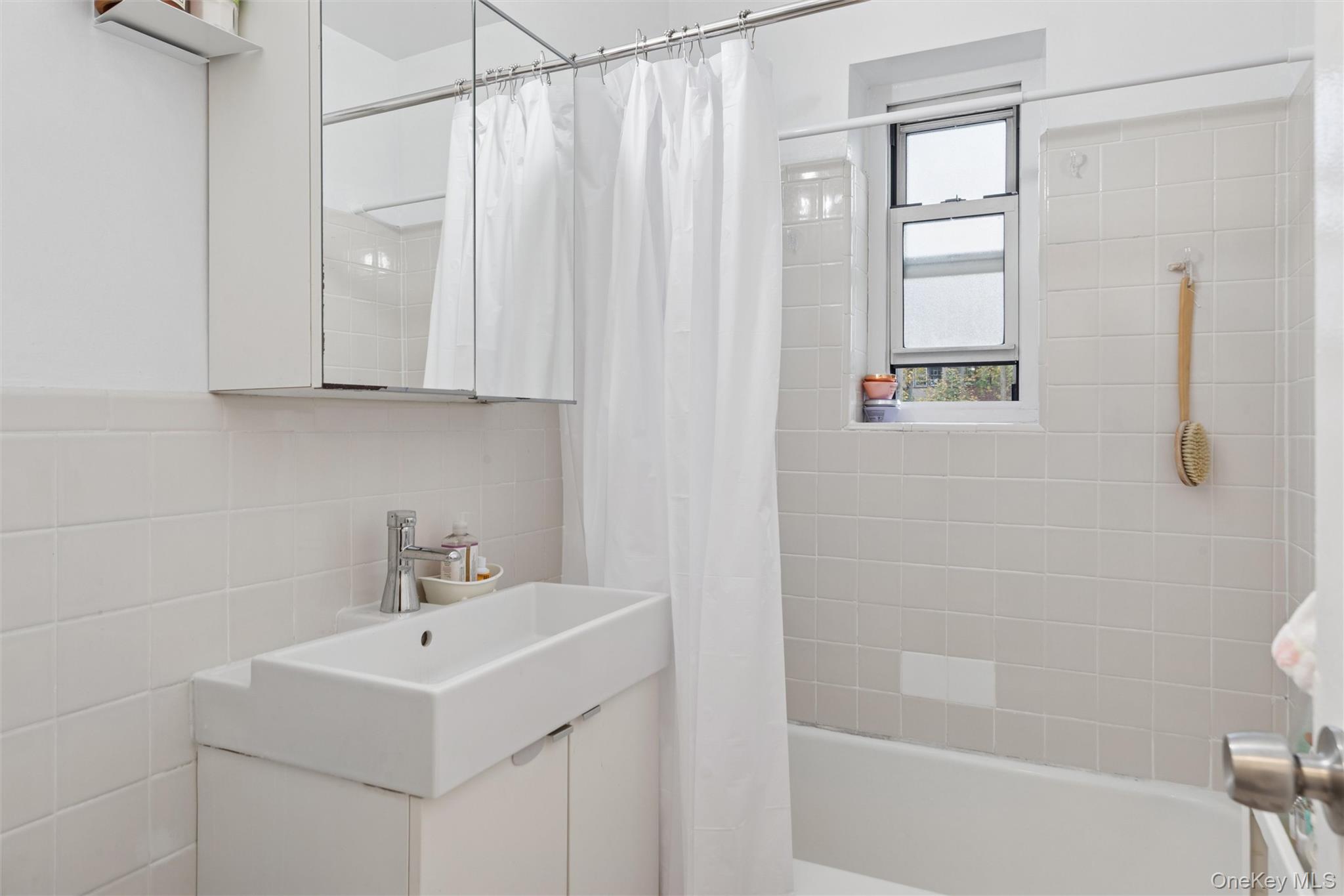 75-02 Austin Street, Unit 2C Queens, NY 11375 - Photo 5 of 6 a bathroom with a sink a toilet and shower