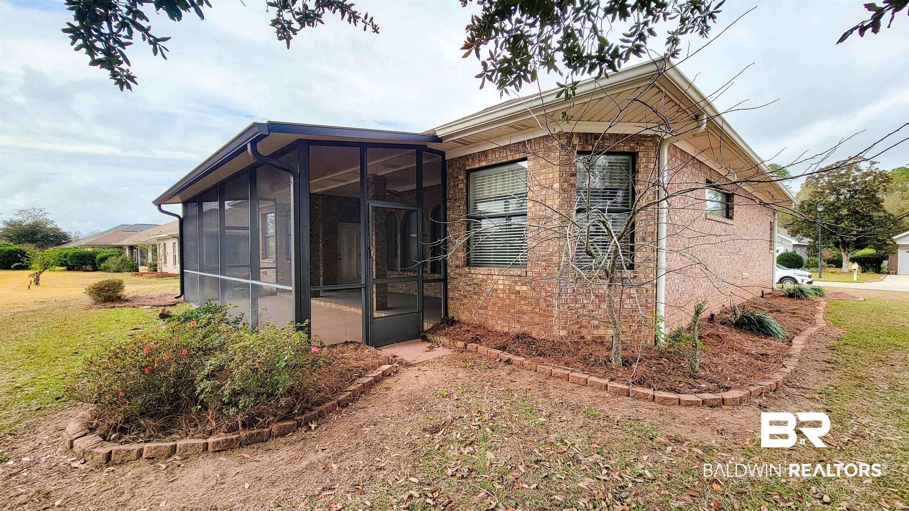214 Hemingway Loop Foley, AL 36535 - Photo 4 of 67 View of side of home featuring brick siding, a lawn, and a sunroom