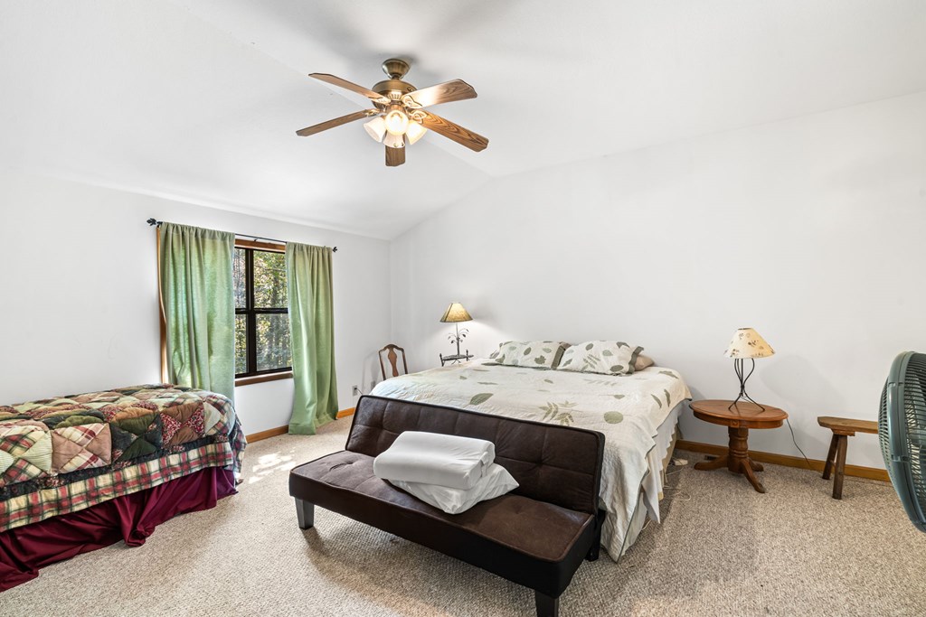 1628 Woods Valley Road Young Harris, GA 30582 - Photo 14 of 36 a bedroom with a bed and a chandelier