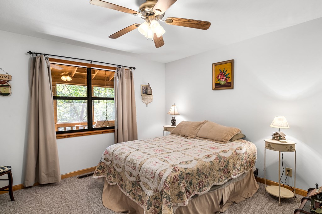 1628 Woods Valley Road Young Harris, GA 30582 - Photo 16 of 36 a bedroom with a bed and a chandelier