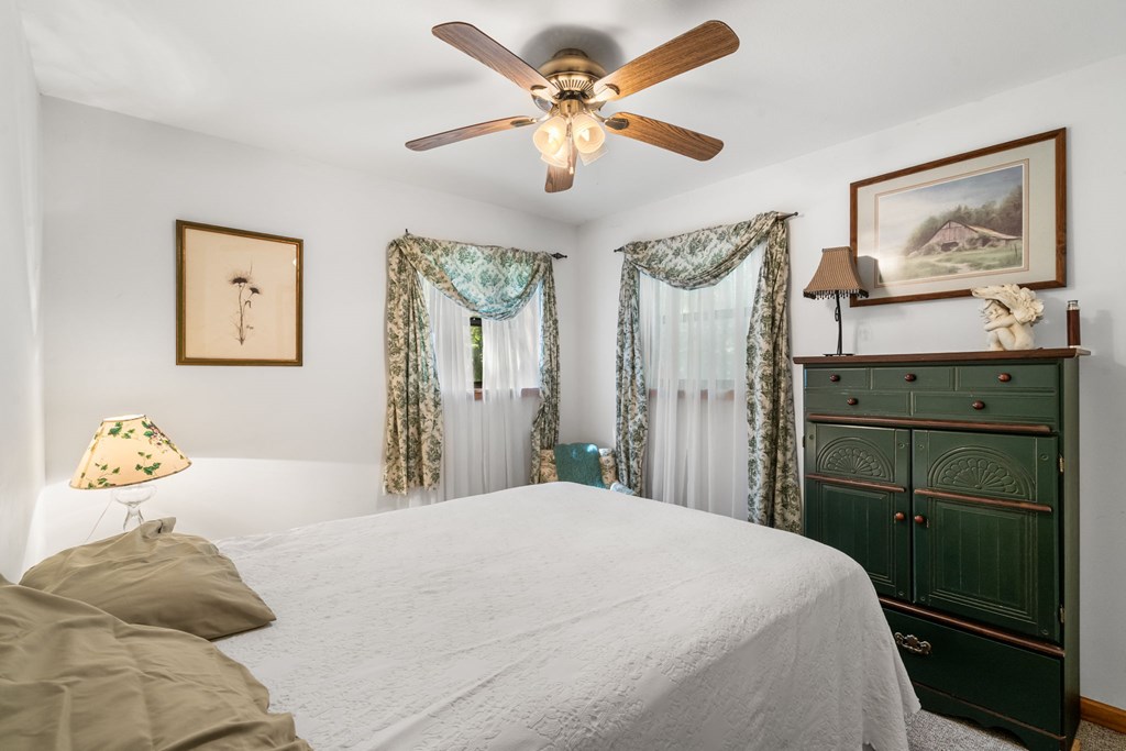 1628 Woods Valley Road Young Harris, GA 30582 - Photo 19 of 36 a bedroom with a bed and a chandelier