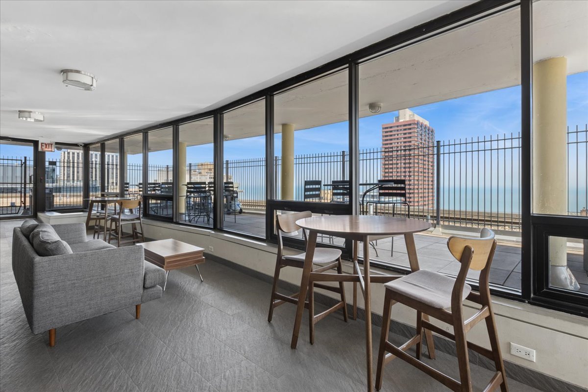 2930 North Sheridan Road, Unit 1403 Chicago, IL 60657 - Photo 14 of 19 a dining room with furniture and a floor to ceiling window