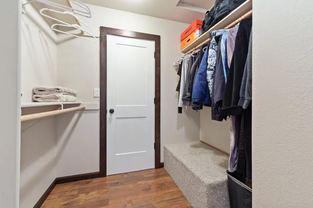 a view of walk in closet with clothes and shoes