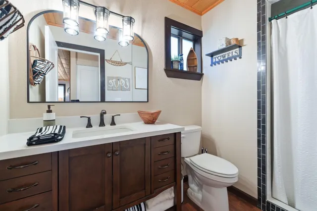 a bathroom with a toilet a sink and mirror