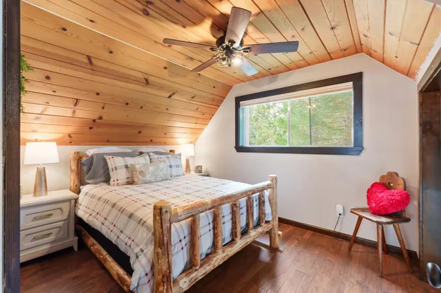 a bedroom with a bed chandelier and a window