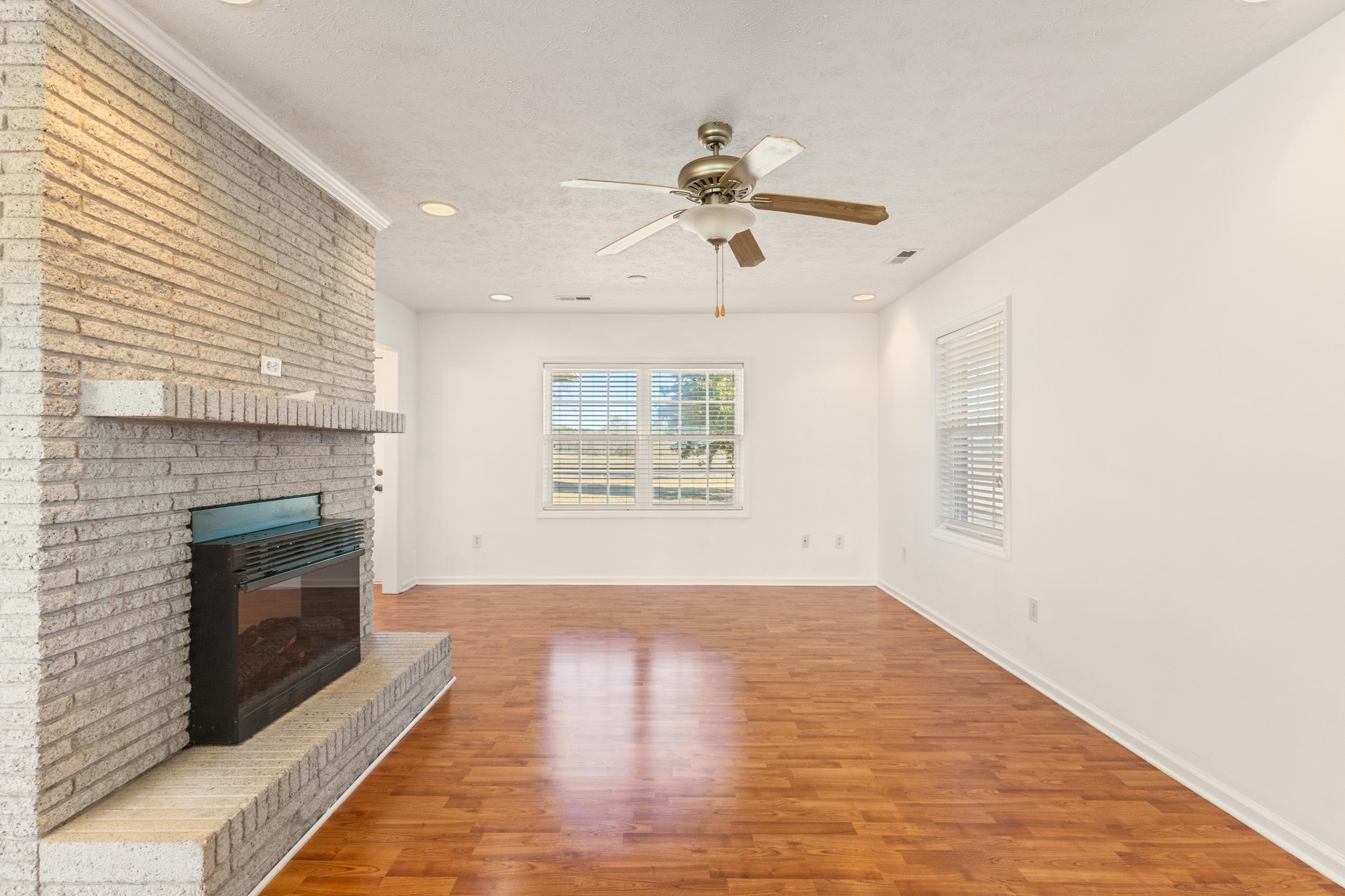 3923 State Rd S-26-33 Green Sea, SC 29545 - Photo 15 of 40 Unfurnished living room with light wood-style flooring, recessed lighting, a brick fireplace, ceiling fan, and a textured ceiling