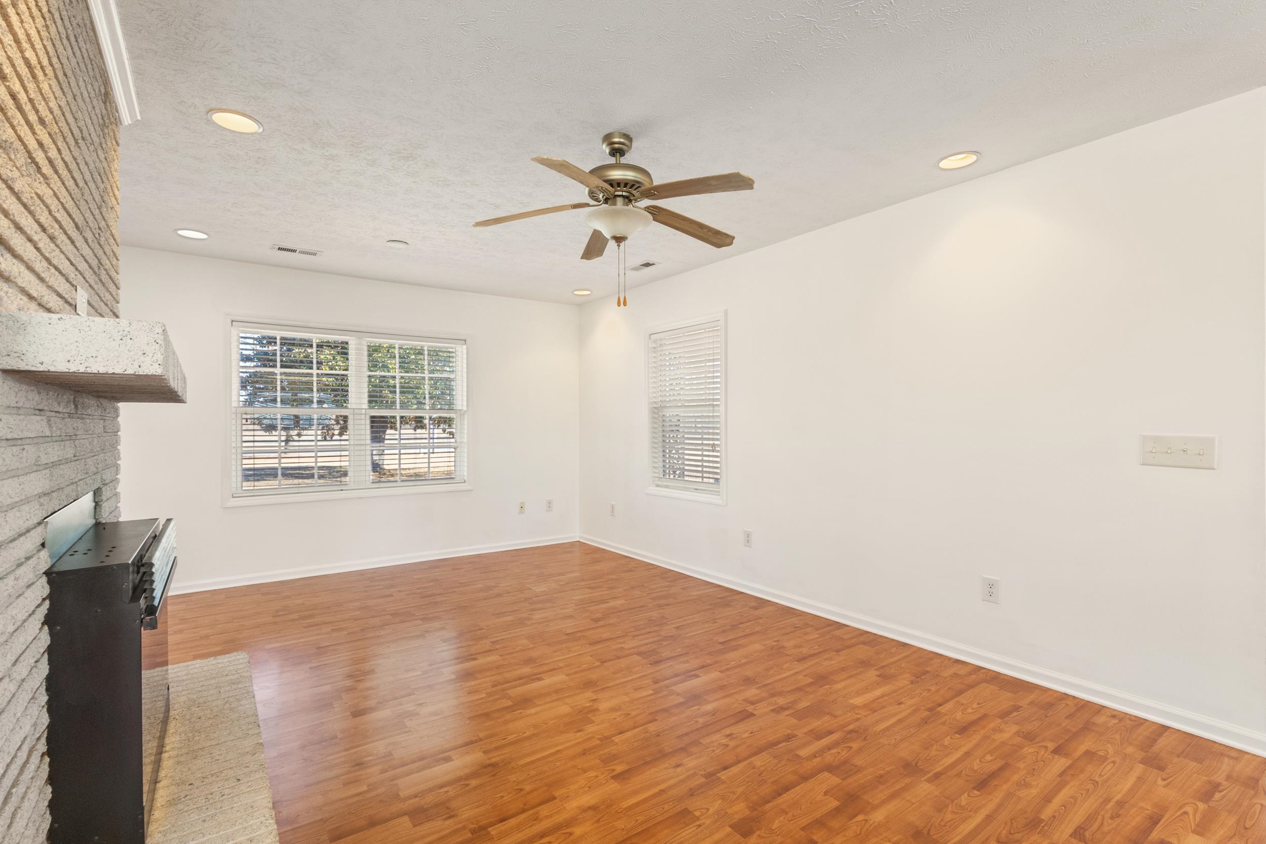 3923 State Rd S-26-33 Green Sea, SC 29545 - Photo 16 of 40 Unfurnished living room with a textured ceiling, recessed lighting, wood finished floors, a ceiling fan, and a brick fireplace