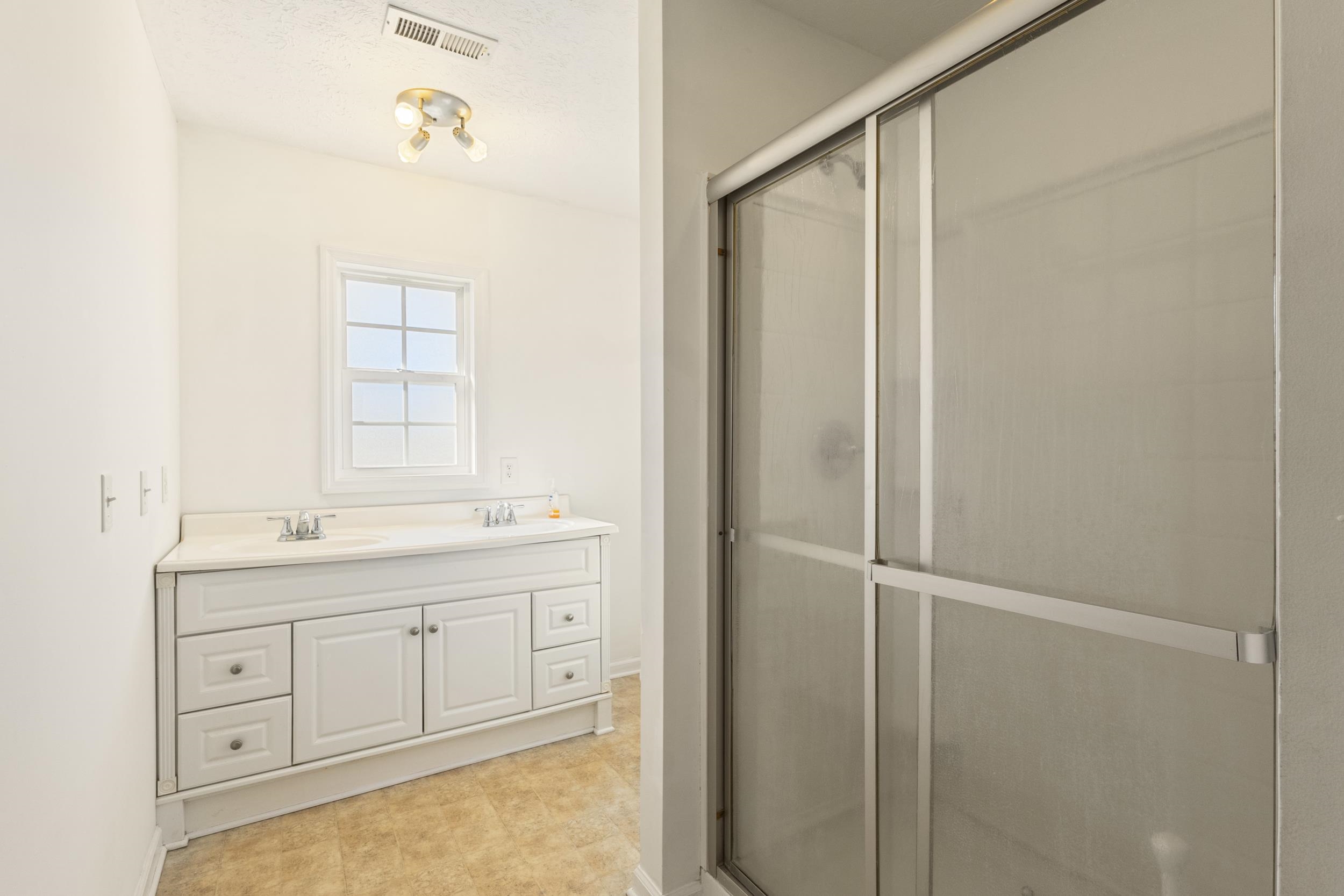 3923 State Rd S-26-33 Green Sea, SC 29545 - Photo 28 of 40 Full bathroom with double vanity, a shower stall, a textured ceiling, and light tile patterned flooring