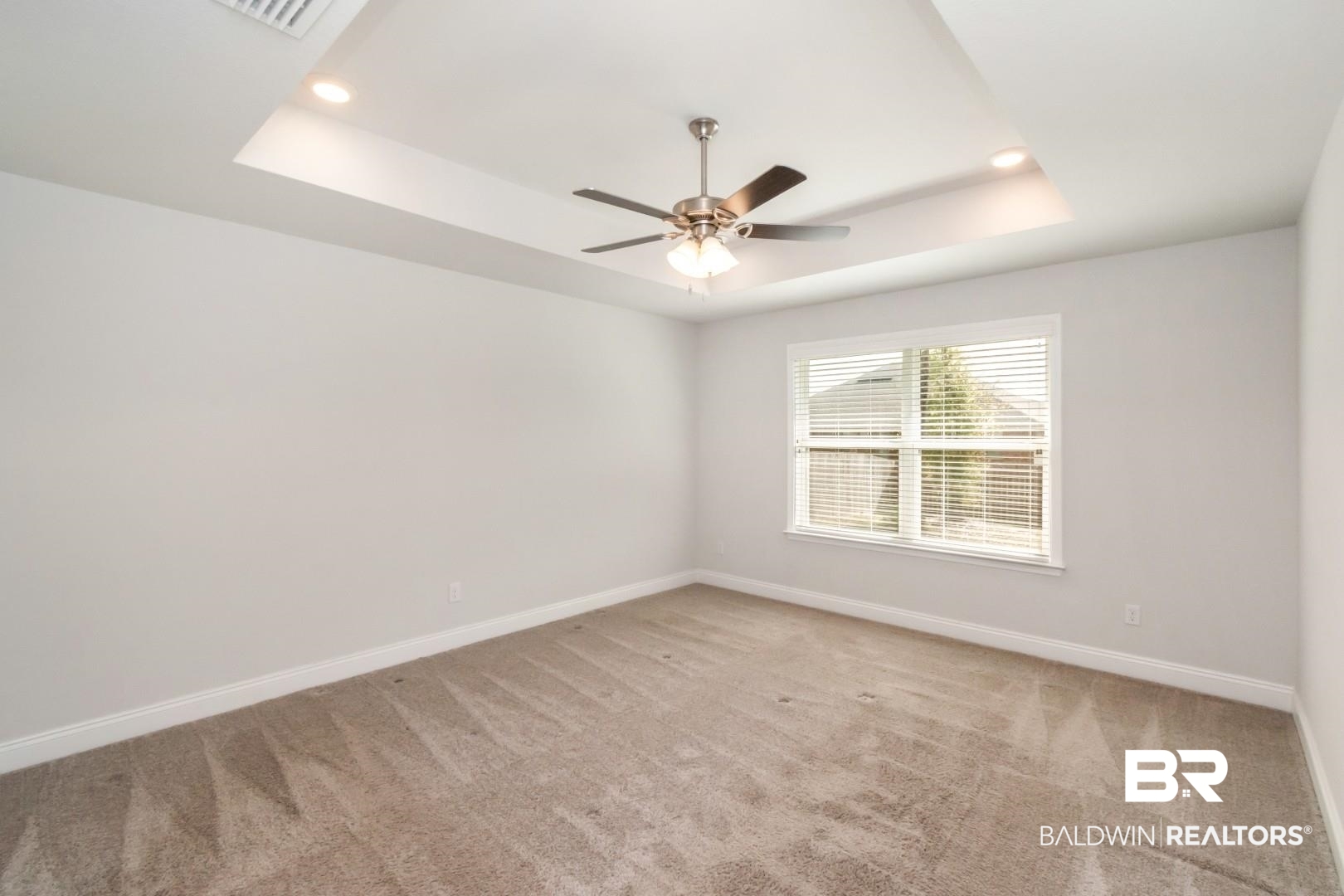 6632 Monarch Circle Mobile, AL 36618 - Photo 18 of 32 Empty room with light carpet, a ceiling fan, a tray ceiling, and recessed lighting