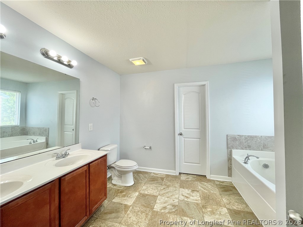 92 Hallow Oak Street Spring Lake, NC 28390 - Photo 9 of 11 a spacious bathroom with a granite countertop sink a toilet and a tub