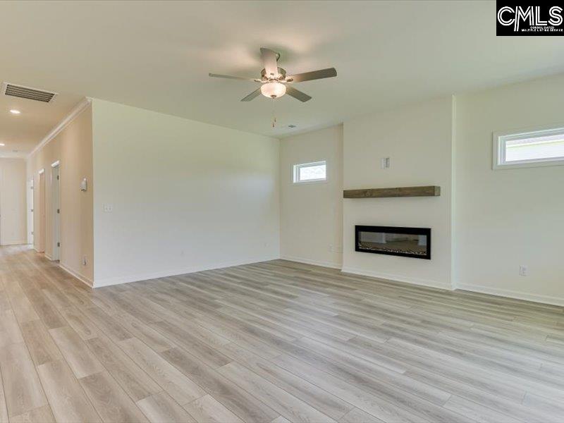 628 Old Charleston Road Pelion, SC 29123 - Photo 10 of 36 a view of an empty room with wooden floor and a fireplace