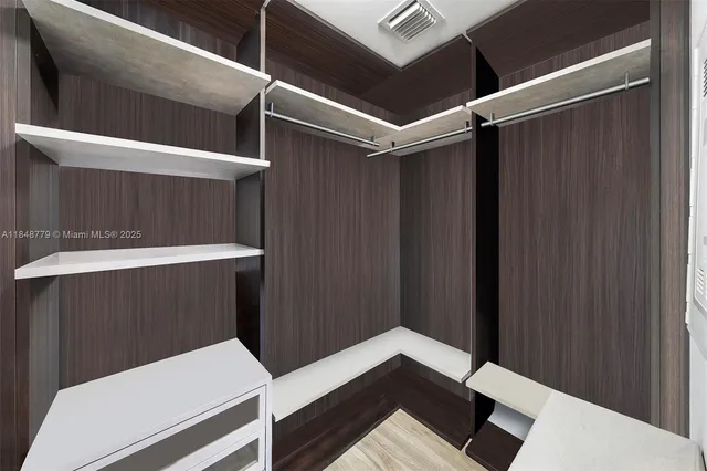 a view of walk in closet with clothes and shoes