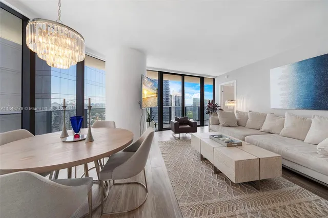 a living room with furniture a chandelier and a large window