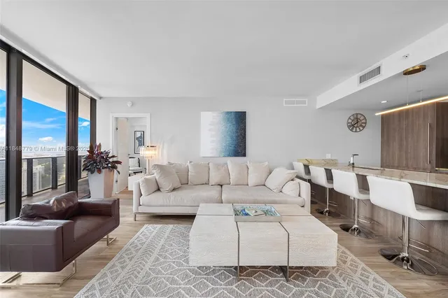 a living room with furniture wooden floor and a large window