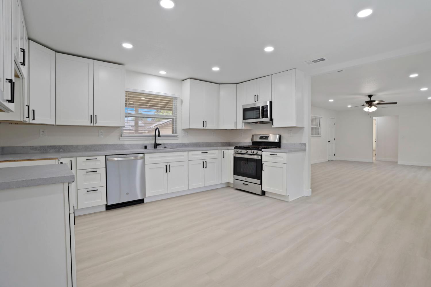 834 North Filbert Street Stockton, CA 95205 - Photo 4 of 22 a kitchen with granite countertop white cabinets and white appliances