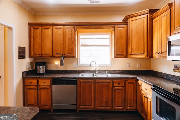 a kitchen with stainless steel appliances granite countertop a sink a stove and a microwave