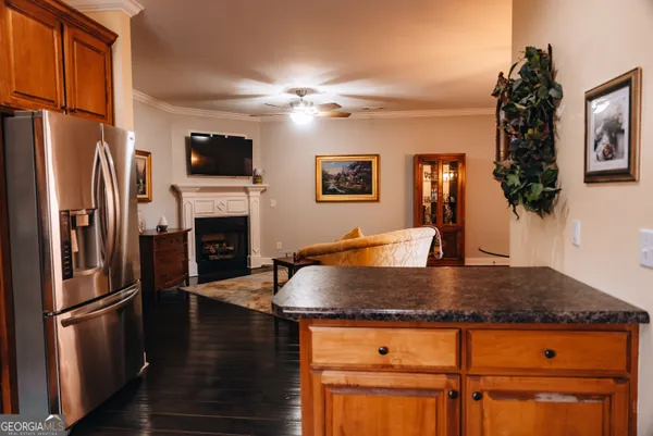 a kitchen with stainless steel appliances granite countertop a refrigerator a stove and a sink with wooden floor