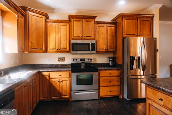 a kitchen with stainless steel appliances granite countertop a refrigerator stove and sink