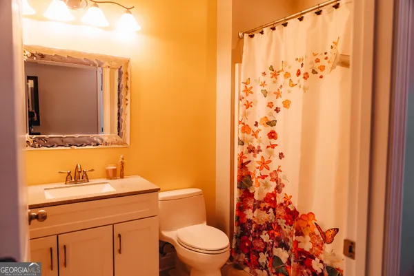 a bathroom with a sink a toilet and shower curtain