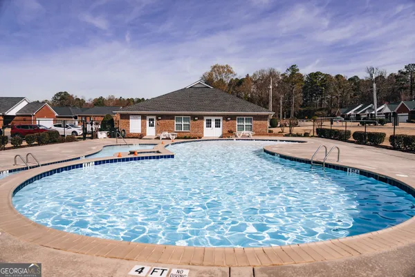 a view of a house with swimming pool and sitting area