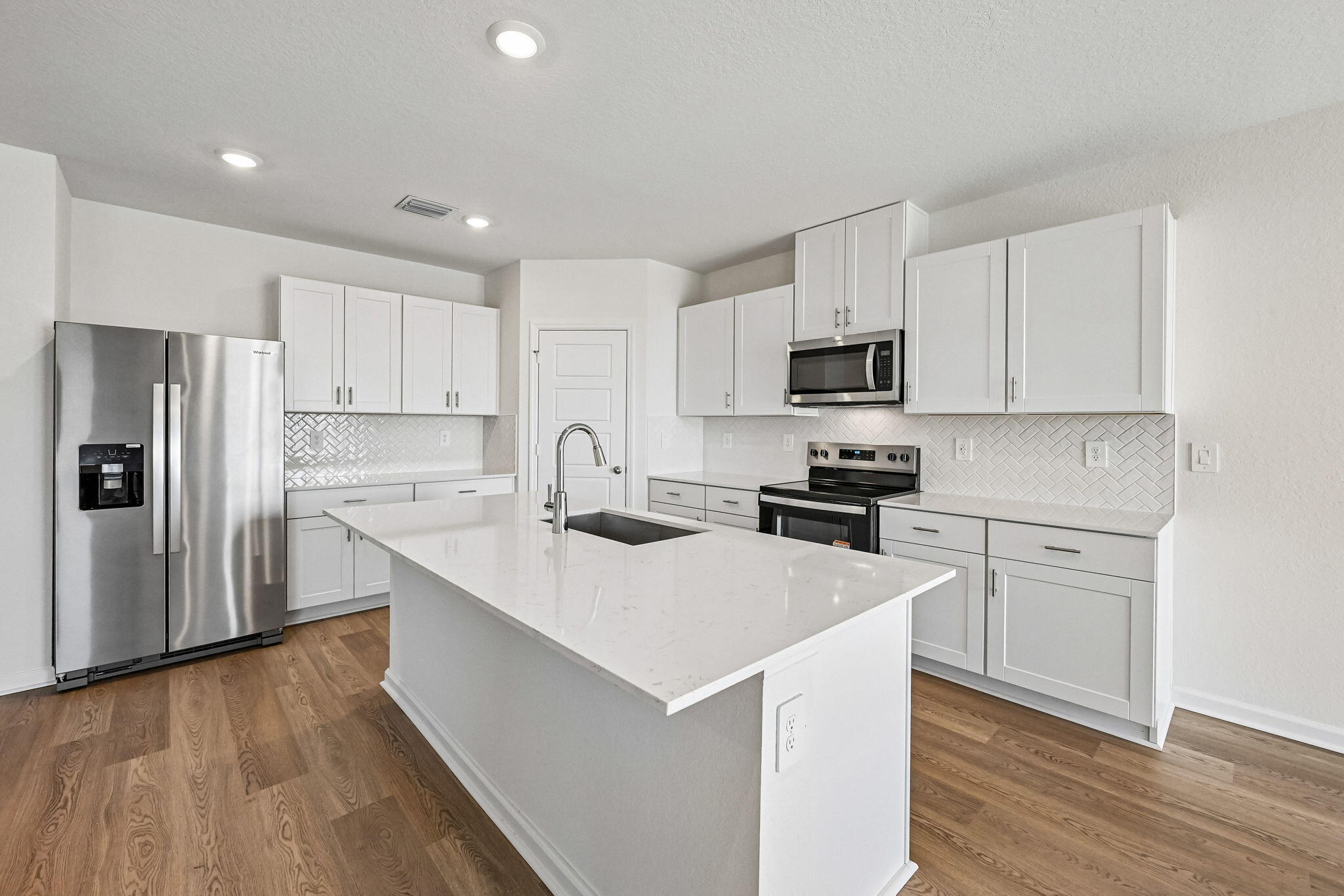 14503 Southwest New Dawn Road Indiantown, FL 34956 - Photo 11 of 42 a kitchen with wooden cabinets and stainless steel appliances