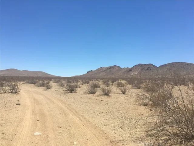 a view of mountain with sunset in background